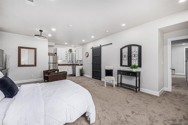 bedroom featuring baseboards, a barn door, freestanding refrigerator, and light colored carpet