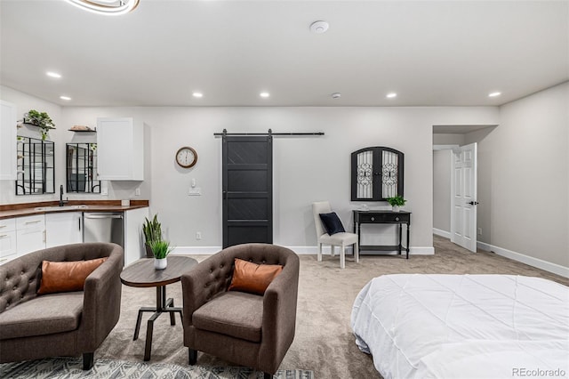 bedroom featuring light carpet, a barn door, baseboards, a sink, and recessed lighting