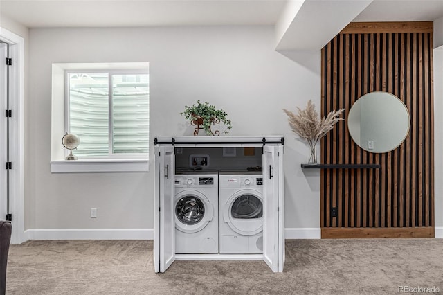 clothes washing area featuring baseboards, laundry area, carpet, and washer and dryer