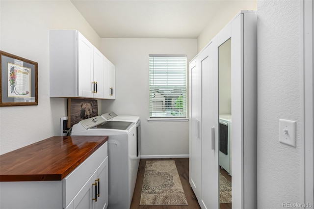 laundry area with cabinet space, dark wood finished floors, baseboards, and separate washer and dryer