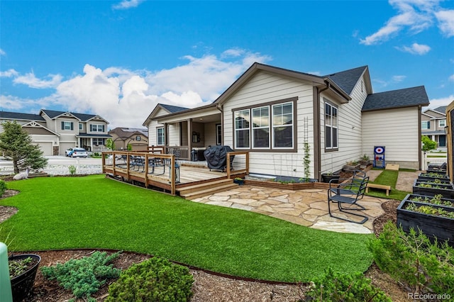 back of house featuring roof with shingles, a yard, a patio, a deck, and a residential view