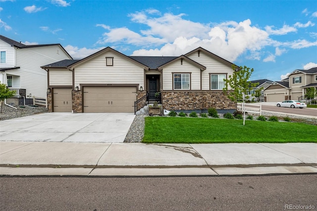 ranch-style home with a garage, concrete driveway, a front lawn, and stone siding