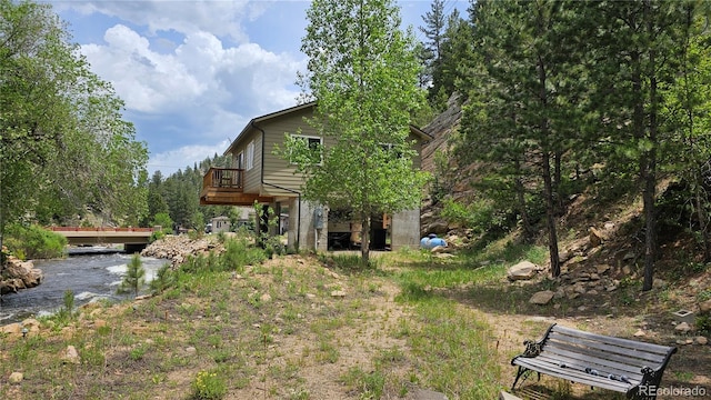 view of yard with a deck with water view