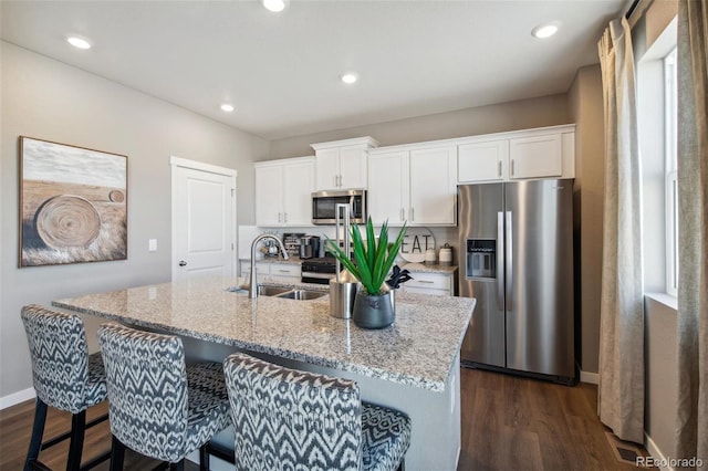 kitchen with a kitchen island with sink, appliances with stainless steel finishes, sink, and white cabinets