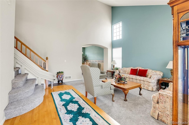 19939 E Belleview Ln, Centennial, CO 80015 - living room with stairway, visible vents, arched walkways, baseboards, and high vaulted ceiling