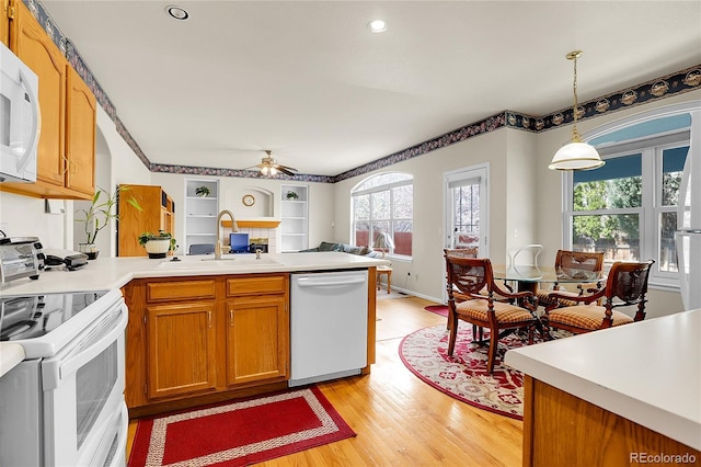 19939 E Belleview Ln, Centennial, CO 80015 - kitchen with a peninsula, light wood-style flooring, a sink, open floor plan, and white appliances