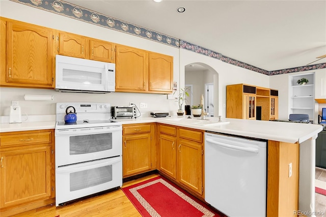 19939 E Belleview Ln, Centennial, CO 80015 - kitchen with a peninsula, light countertops, white appliances, and arched walkways