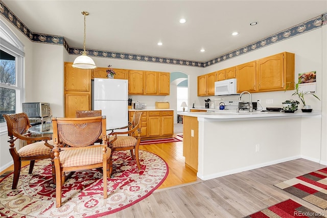 19939 E Belleview Ln, Centennial, CO 80015 - kitchen featuring arched walkways, plenty of natural light, light wood finished floors, and white appliances