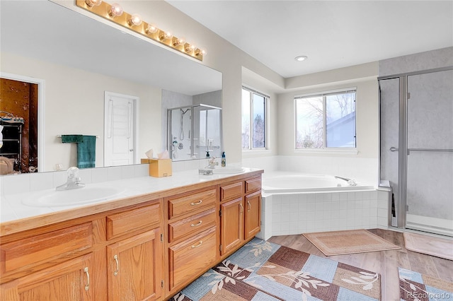 19939 E Belleview Ln, Centennial, CO 80015 - bathroom with a shower stall, a garden tub, wood finished floors, a sink, and double vanity