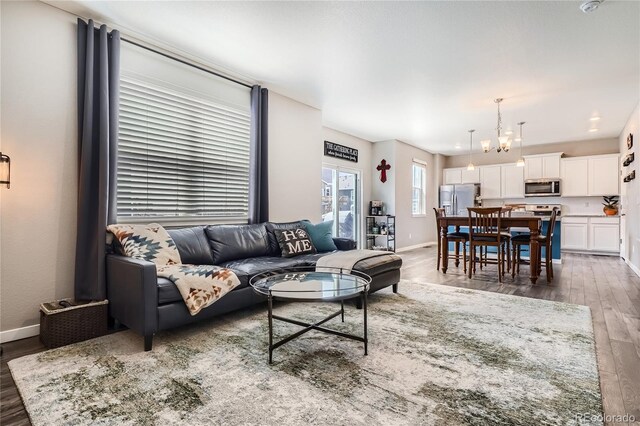 4781 Rosette St, Castle Rock, CO 80104 - living area featuring wood finished floors, a chandelier, and baseboards