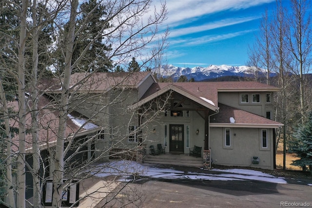 725 Sun Valley Dr, Woodland Park, CO 80863 - view of front facade featuring stucco siding, a mountain view, and roof with shingles