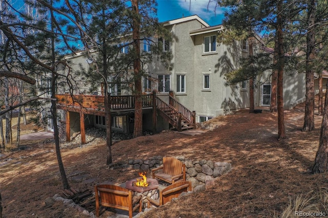 725 Sun Valley Dr, Woodland Park, CO 80863 - back of house featuring a deck, stucco siding, a fire pit, and stairs
