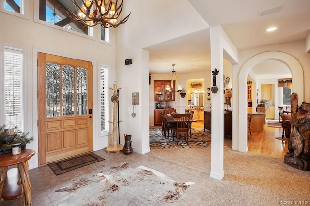 725 Sun Valley Dr, Woodland Park, CO 80863 - foyer entrance with a chandelier, arched walkways, recessed lighting, baseboards, and light tile patterned floors