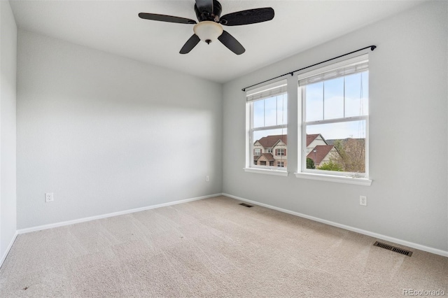 empty room featuring baseboards, carpet, a ceiling fan, and visible vents