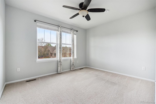 spare room featuring a ceiling fan, baseboards, visible vents, and carpet