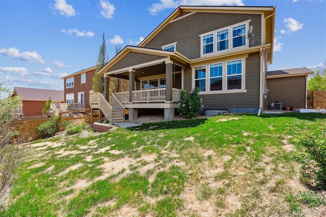 rear view of property with central AC unit, fence, a yard, and a deck