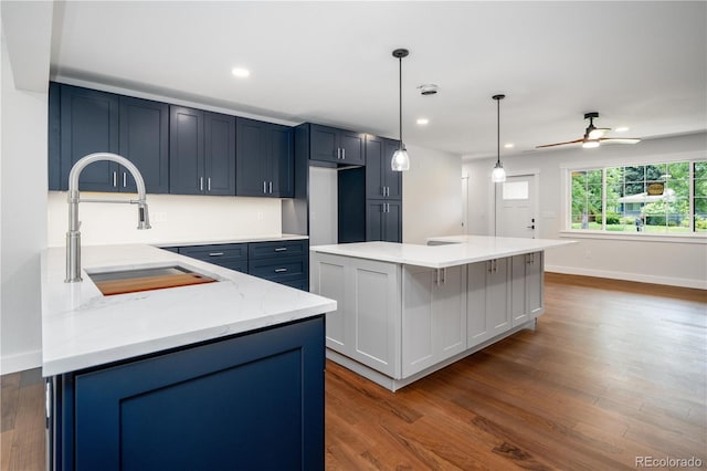 404 S Oneida Way, Denver, CO 80224 - kitchen featuring dark wood-style floors, recessed lighting, a kitchen island, light stone counters, and a ceiling fan