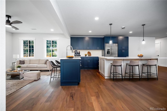 404 S Oneida Way, Denver, CO 80224 - kitchen with stainless steel refrigerator with ice dispenser, blue cabinets, a kitchen breakfast bar, dark wood-type flooring, and light countertops