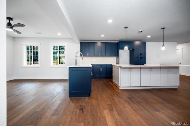 404 S Oneida Way, Denver, CO 80224 - kitchen with blue cabinets, light countertops, dark wood-type flooring, ceiling fan, and a kitchen island