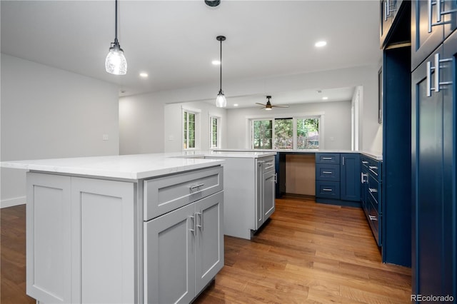 404 S Oneida Way, Denver, CO 80224 - kitchen with a center island, light wood finished floors, blue cabinetry, recessed lighting, and ceiling fan