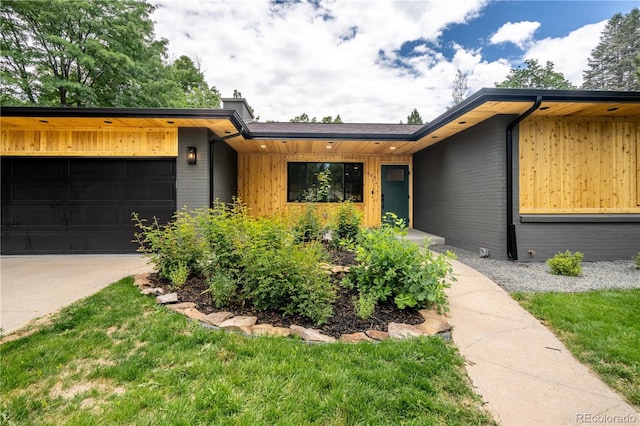 404 S Oneida Way, Denver, CO 80224 - view of front of house with an attached garage, brick siding, driveway, and a chimney