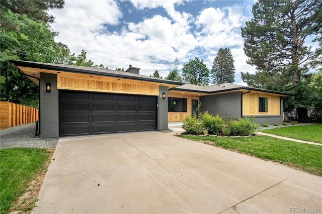 404 S Oneida Way, Denver, CO 80224 - view of front of home with a garage, brick siding, driveway, and a chimney