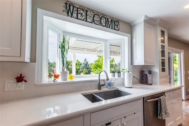 kitchen featuring sink, stainless steel dishwasher, and white cabinets