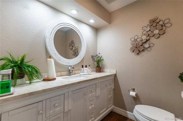 bathroom with vanity, hardwood / wood-style floors, and toilet