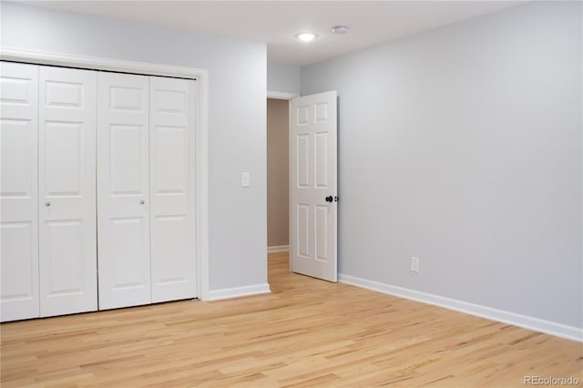 unfurnished bedroom featuring light hardwood / wood-style floors and a closet