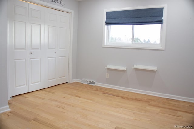 unfurnished bedroom featuring light hardwood / wood-style flooring and a closet