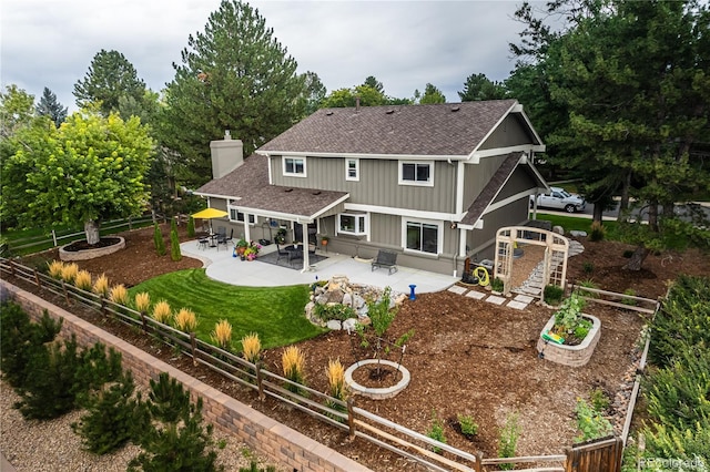 back of house with a yard and a patio