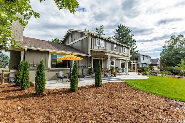 rear view of property featuring a yard and a patio