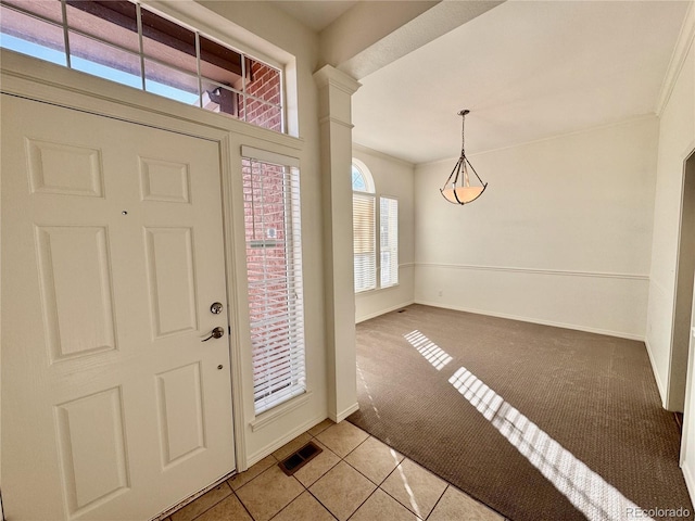 entrance foyer with light carpet, baseboards, visible vents, and ornamental molding