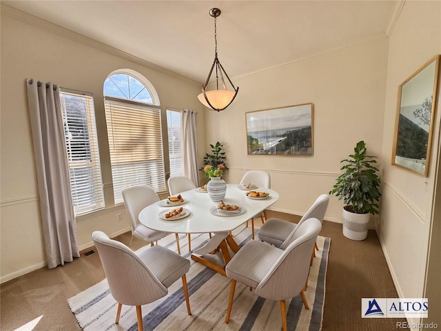 dining room with light colored carpet, crown molding, and baseboards