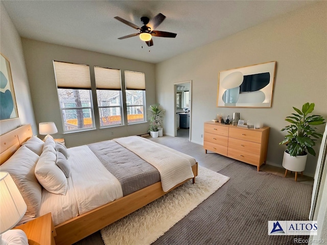 carpeted bedroom with baseboards and ensuite bath