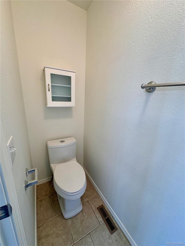 bathroom with toilet, baseboards, visible vents, and tile patterned floors