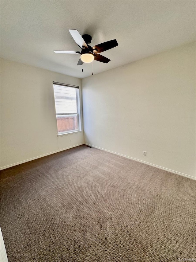 carpeted spare room with a ceiling fan, a textured ceiling, and baseboards