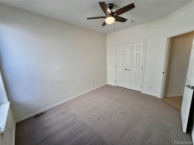 unfurnished bedroom featuring visible vents, baseboards, ceiling fan, carpet floors, and a closet