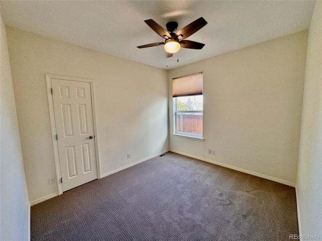 carpeted spare room with baseboards and a ceiling fan