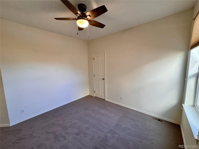 empty room with ceiling fan, baseboards, visible vents, and dark colored carpet