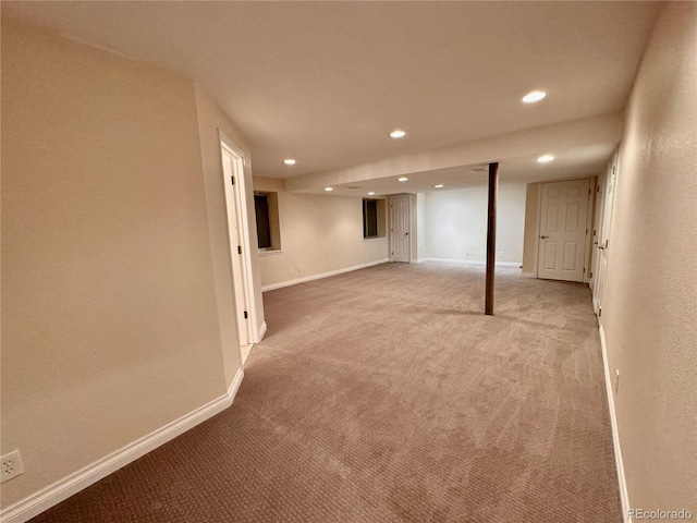 finished basement featuring light carpet, baseboards, and recessed lighting