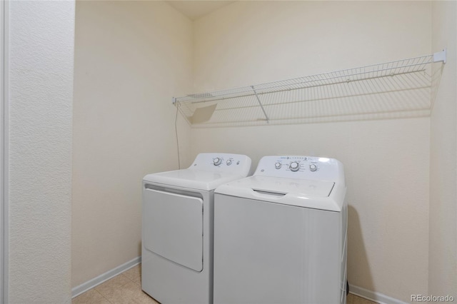 clothes washing area with light tile patterned floors and washing machine and clothes dryer