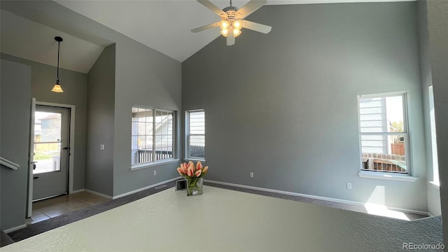 interior space with baseboards, a ceiling fan, and high vaulted ceiling