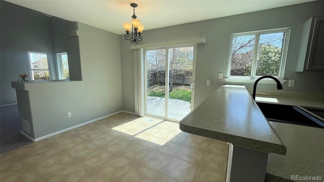 dining room featuring baseboards, a notable chandelier, plenty of natural light, and light tile patterned floors