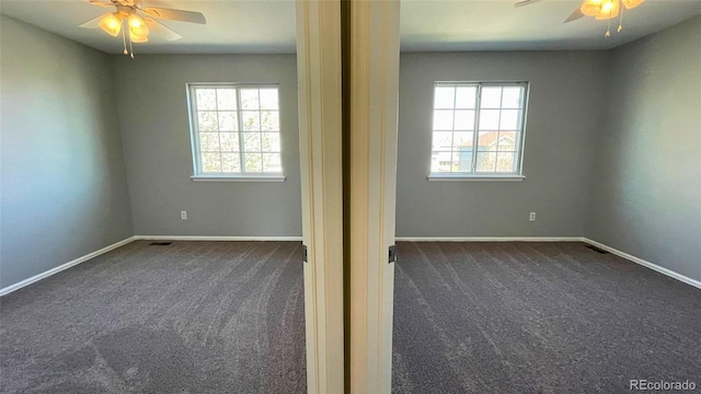 unfurnished bedroom with dark carpet, a ceiling fan, and baseboards
