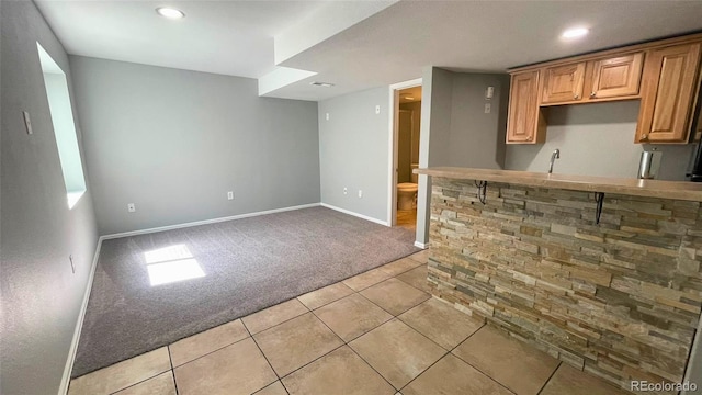 kitchen featuring baseboards, recessed lighting, light tile patterned flooring, and light carpet