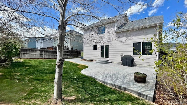rear view of property with fence, a shingled roof, a yard, and a patio area