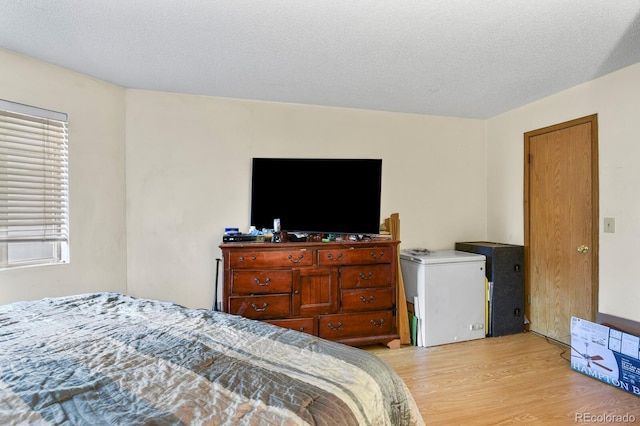 bedroom featuring light wood-type flooring and a textured ceiling