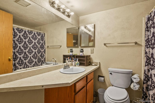 bathroom featuring curtained shower, visible vents, a textured wall, toilet, and vanity