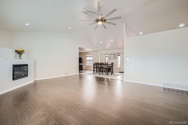 unfurnished living room with ceiling fan, dark wood-type flooring, and lofted ceiling